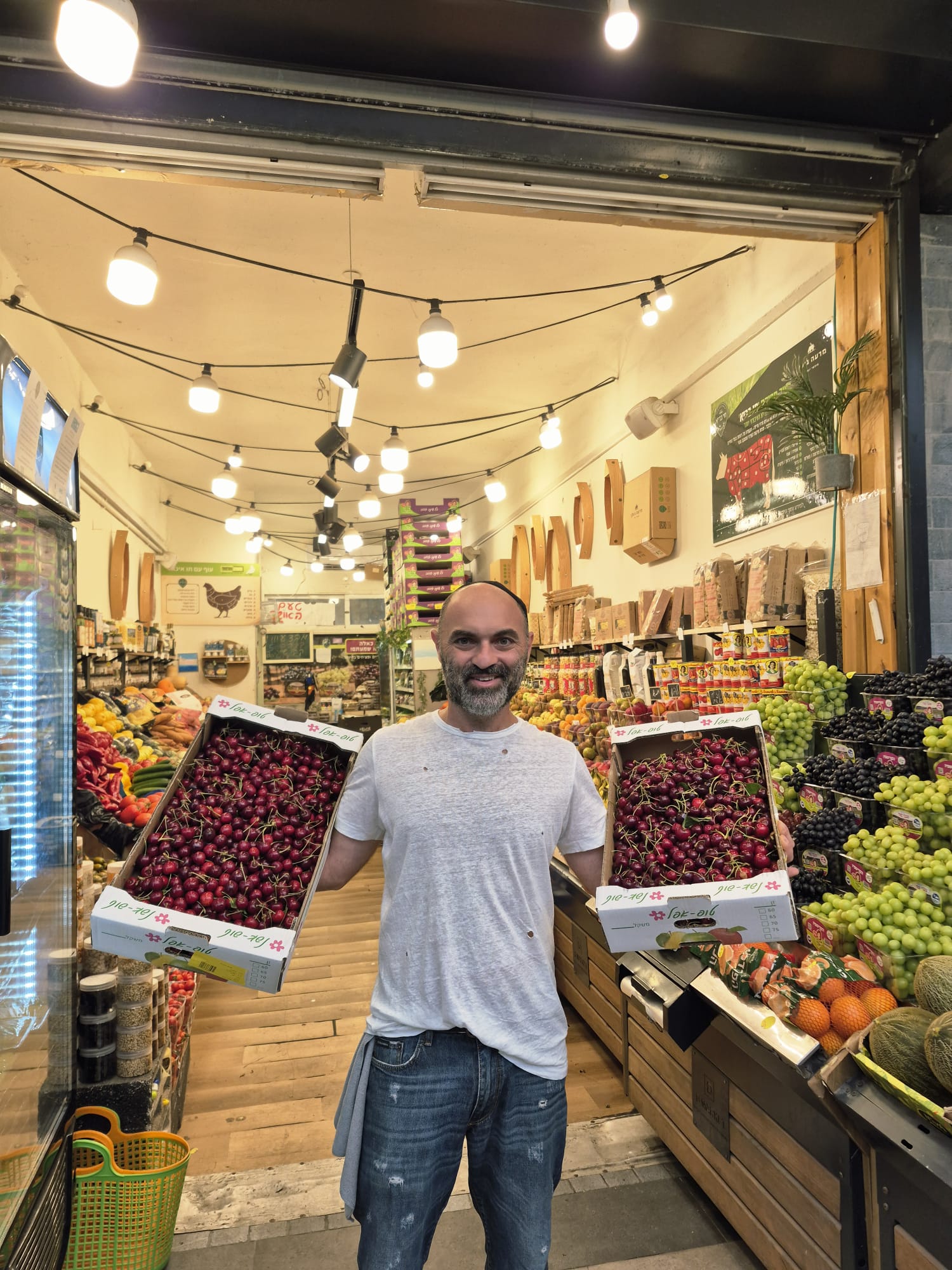 רמי, הבעלים של טעם האושר, מחזיק דובדבנים טריים